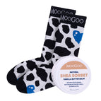 MooGoo Cracked Heels Set featuring a pair of MooGoo branded socks with a black and white cow print and blue hearts, shown next to a round tin of MooGoo Natural Shea Sorbet Vanilla Butter Balm on a white background. Hydrating foot treatment for dry heels and overnight repair.